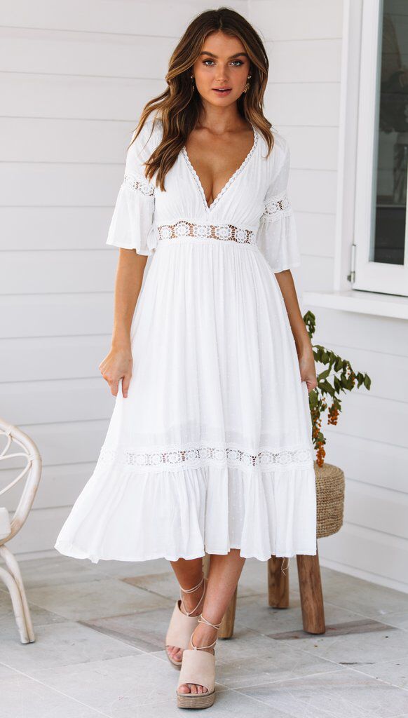 Vestido blanco de encaje con escote en V y dobladillo con volantes