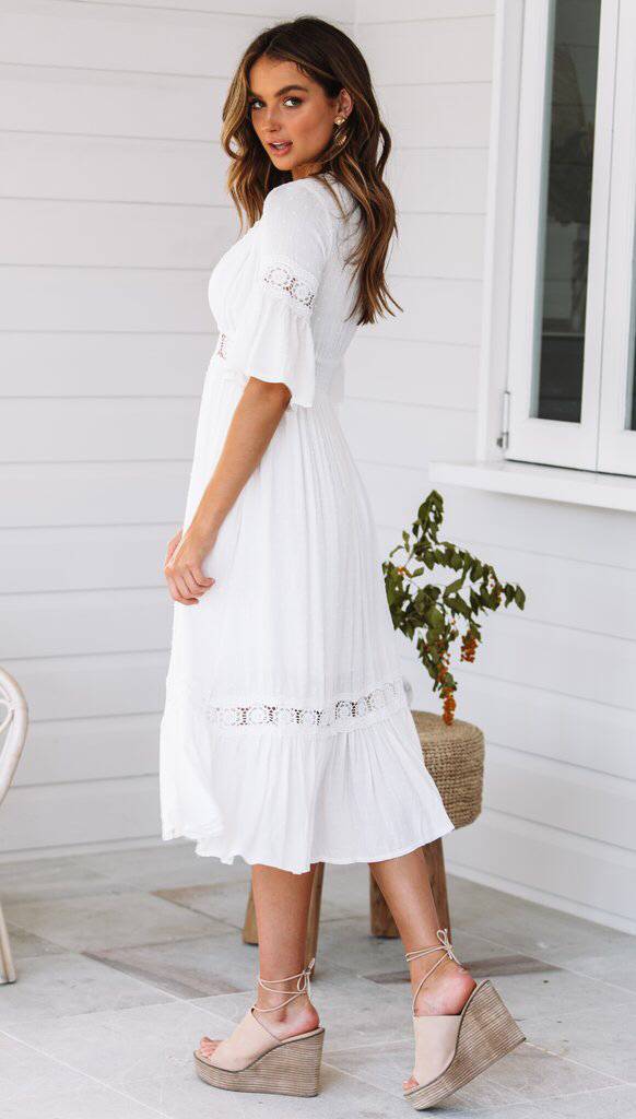 Vestido blanco de encaje con escote en V y dobladillo con volantes