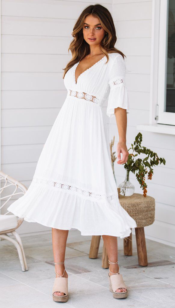 Vestido blanco de encaje con escote en V y dobladillo con volantes