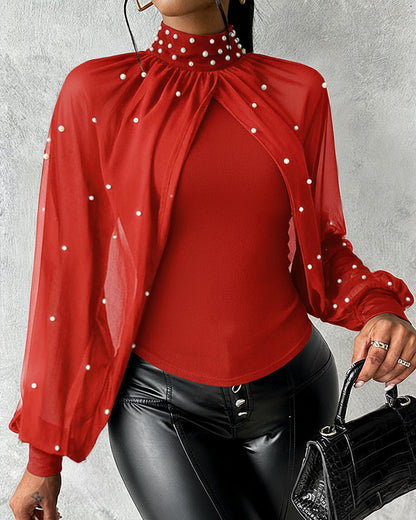 Top ajustado de chiffon con cuello alto, drapeado y manga capa; paneles entrelazados, fruncido y espalda con recorte; con perlas decorativas