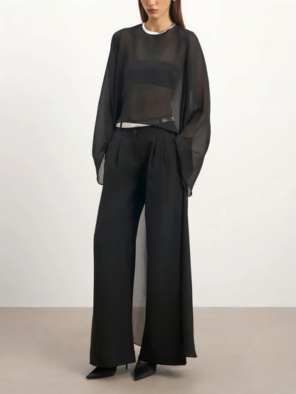 Elegante blusa con capa de gasa translúcida y jeans de silueta curva